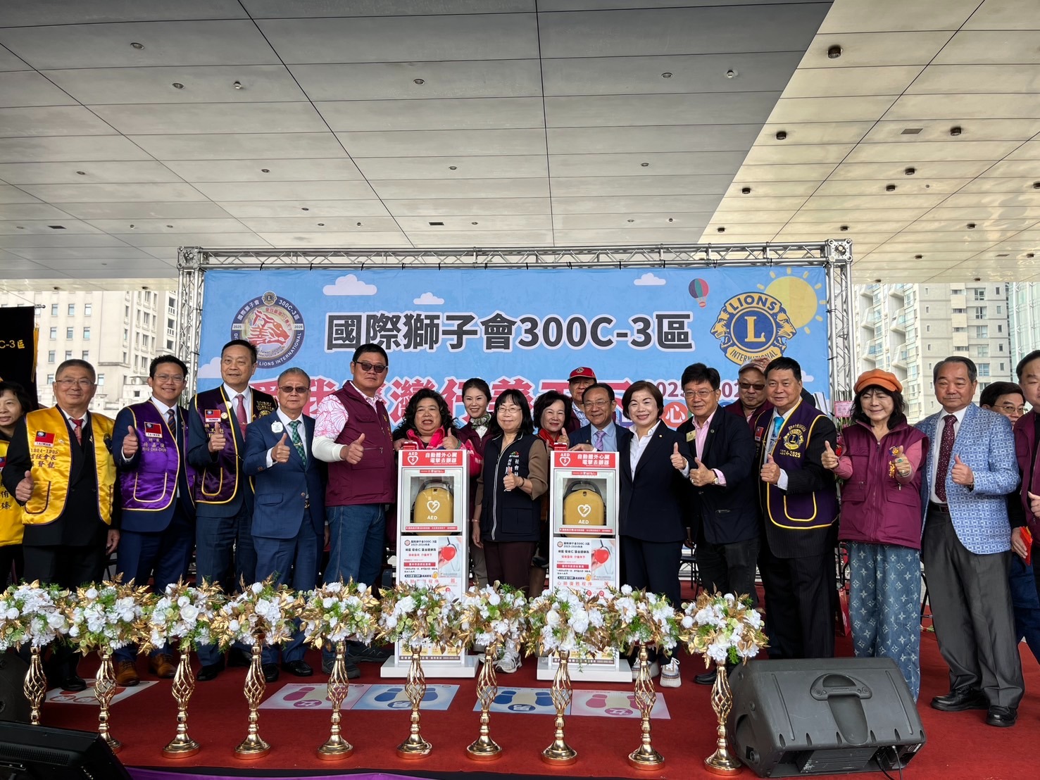 國際獅子會300C-3區舉辦「愛我臺灣・行善天下」愛心園遊會，捐贈AED予市府社會局，社會局長廖靜芝與總監梁俊仁及獅友、立法委員楊瓊瓔、國際獅子會300 C1區總監林玉彪、300C C2區總監許吉本及各分會獅友出席；市議員林祈烽、陳淑華也派代表共襄盛舉貴賓合影，展現公私協力推動公益的行動力。翻攝畫面